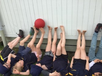 We are cooperatively passing the ball along the wall with our feet